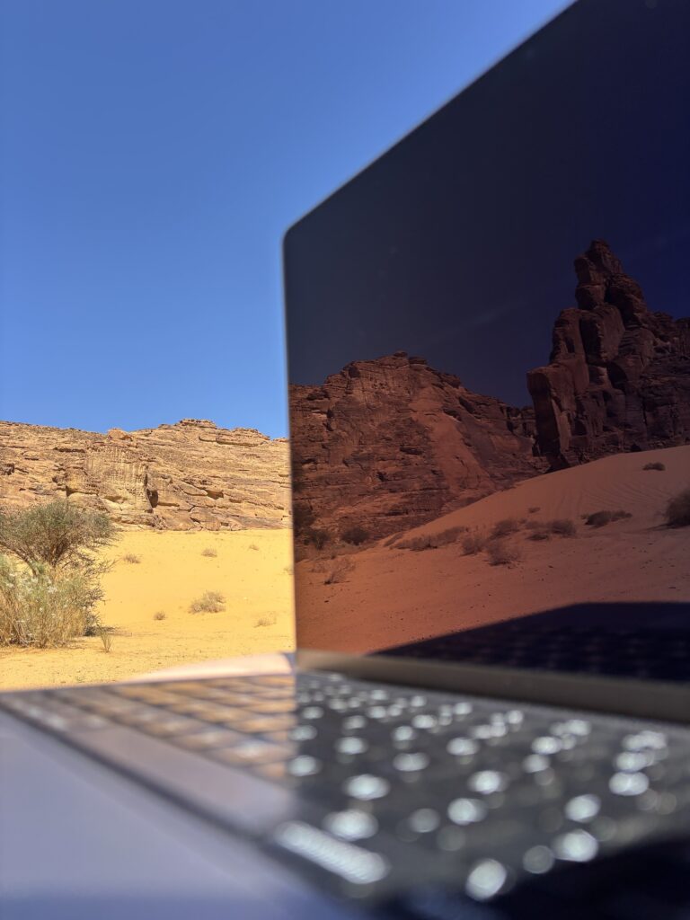 Een laptop die wordt gebruikt voor online adverteren met reflectie van bergen in het scherm.