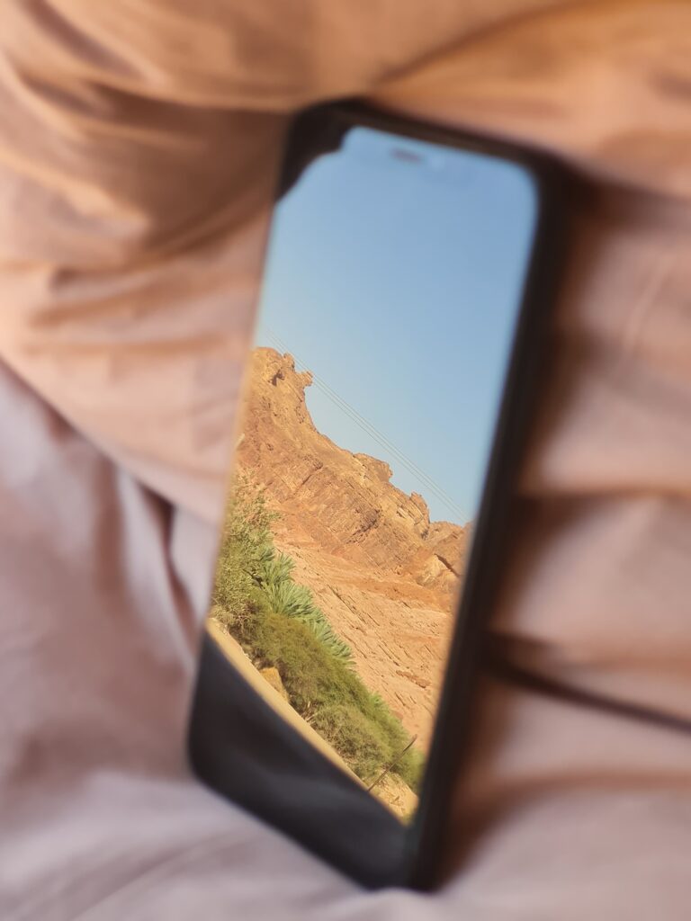 Telefoon voor online social media marketing met reflectie van bergen op het scherm.